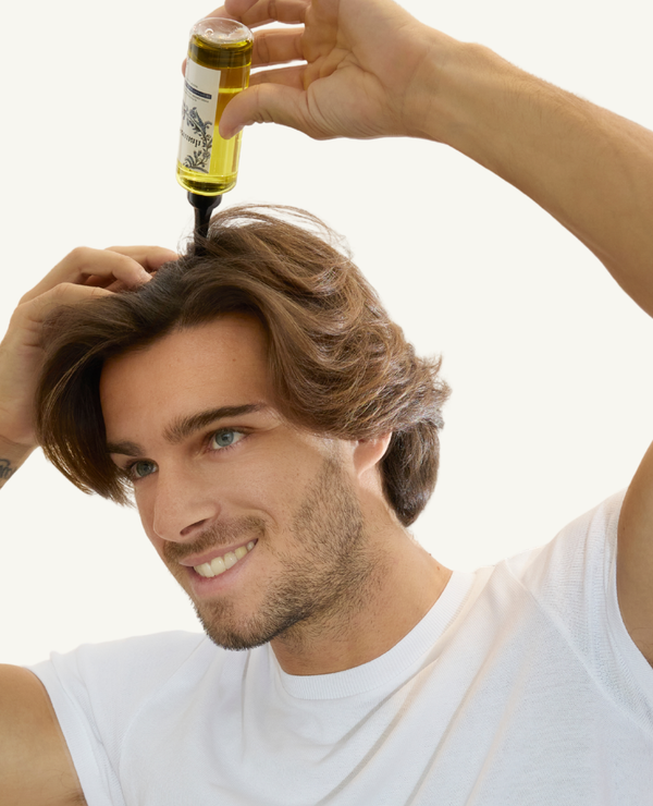 Male model holding the Afsennah Custom Hair Growth Oil for men